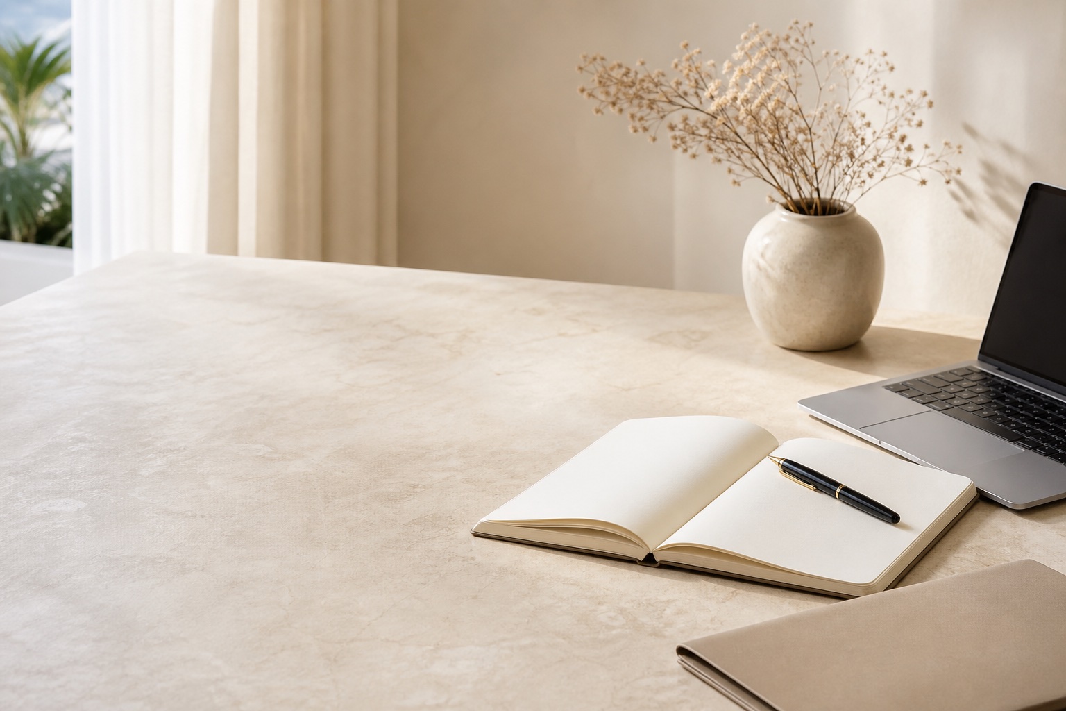 Escritorio ordenado con agenda, portátil y flores secas